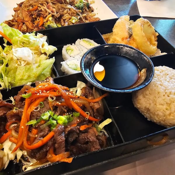 Chopstix 2 sushi bento box with beef, rice, salad, tempura, and sushi rolls.