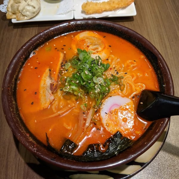 Spicy ramen with pork, egg, scallions, and fish cake, served with gyoza and tempura shrimp.